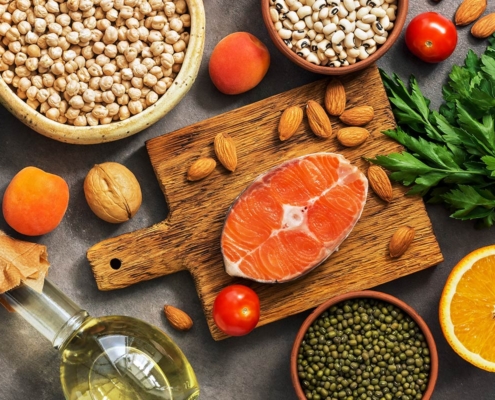 salmon, grains, oil, and herbs on a cutting board