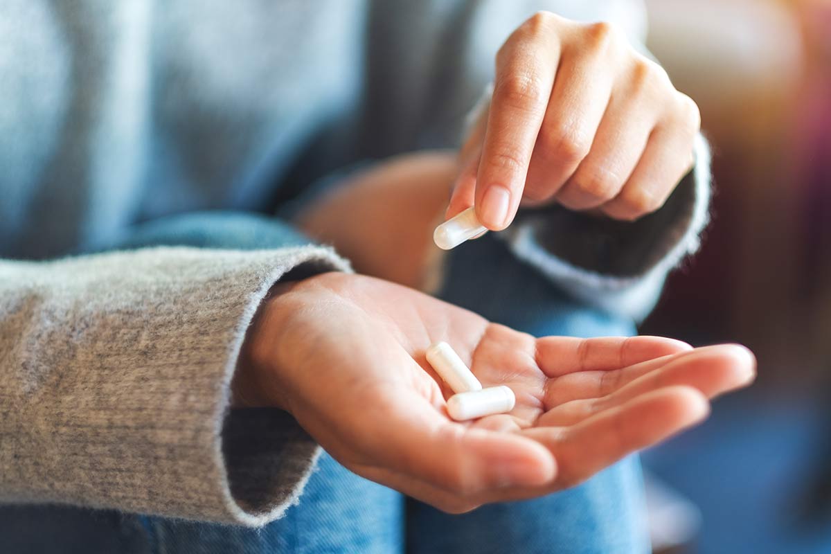 woman holding a nutritional supplement capsule in her hands