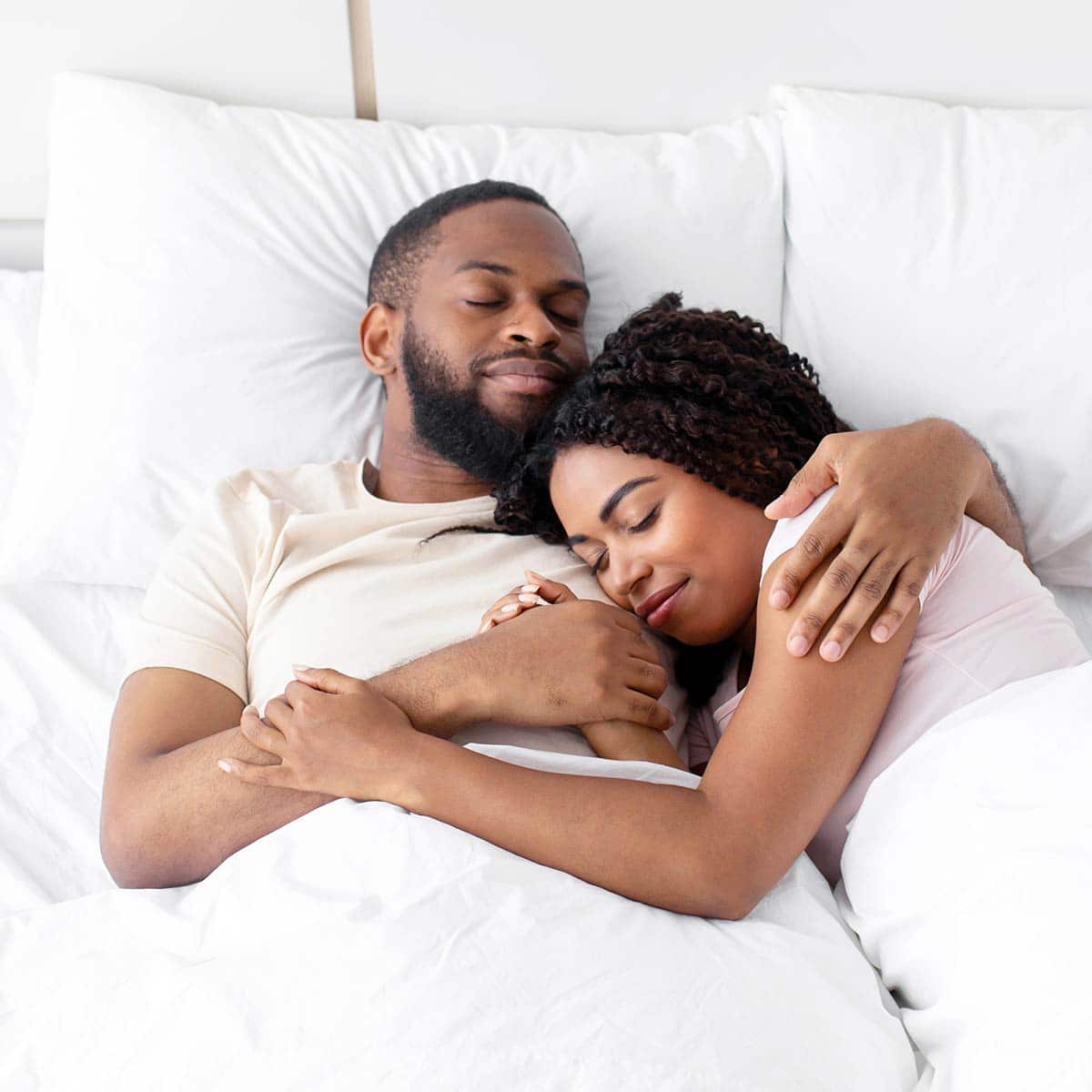 man and woman sleeping in their bed