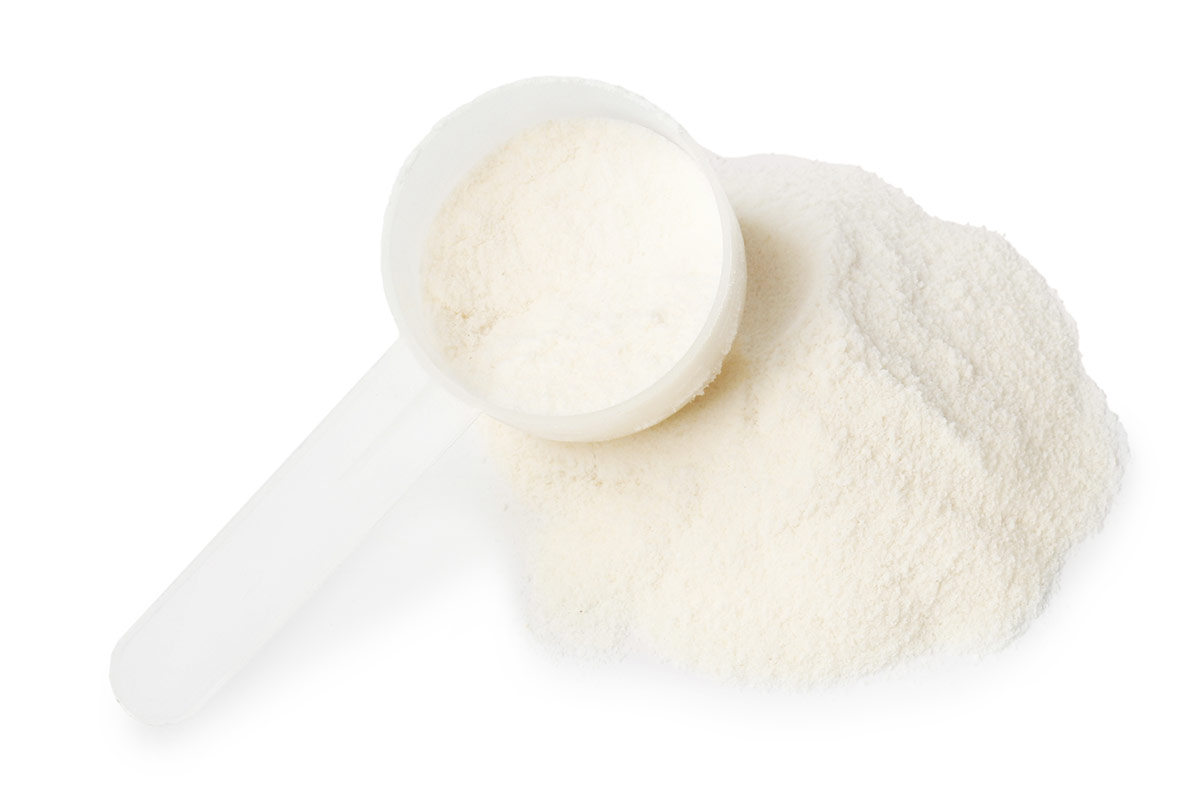 collagen powder in a scoop next to a pile of collagen powder