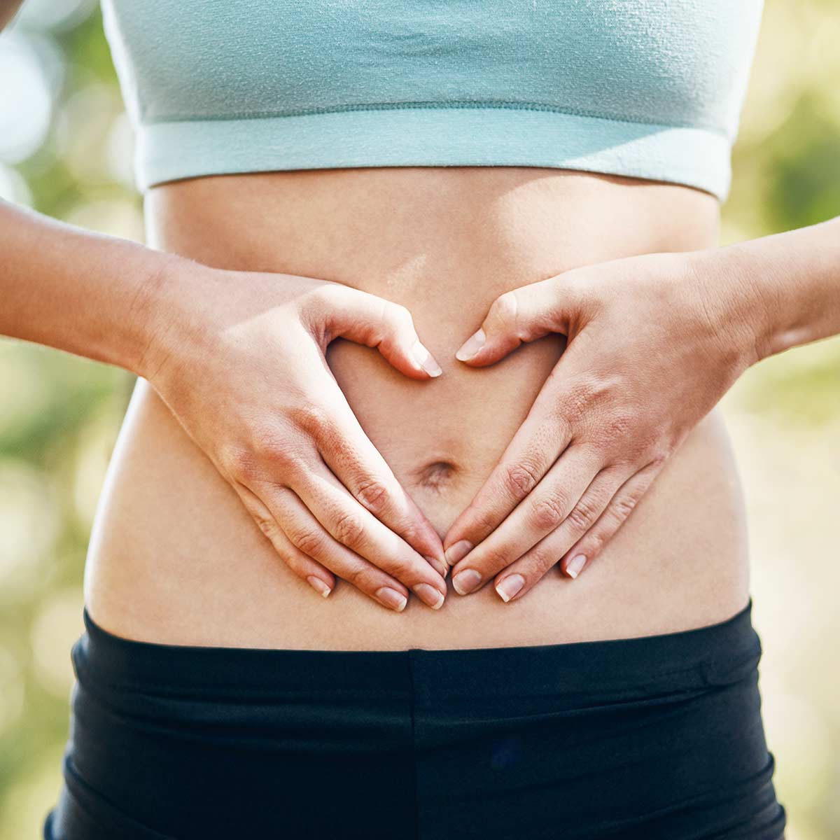 Woman holding her stomach to represent digestive health