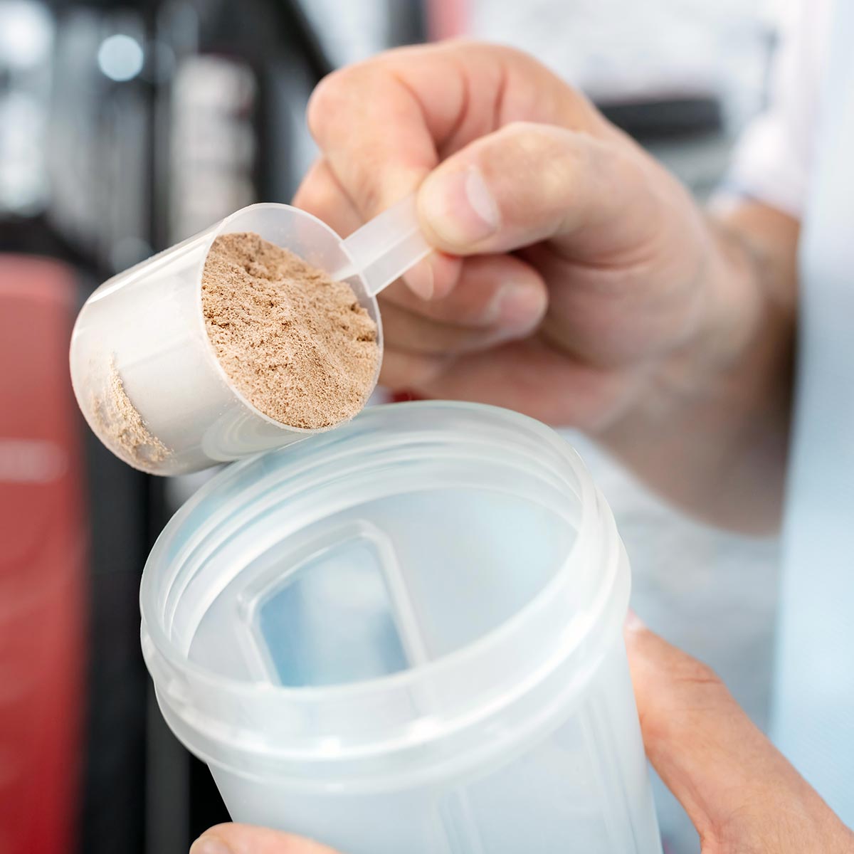 protein powder being poured into a shaker bottle