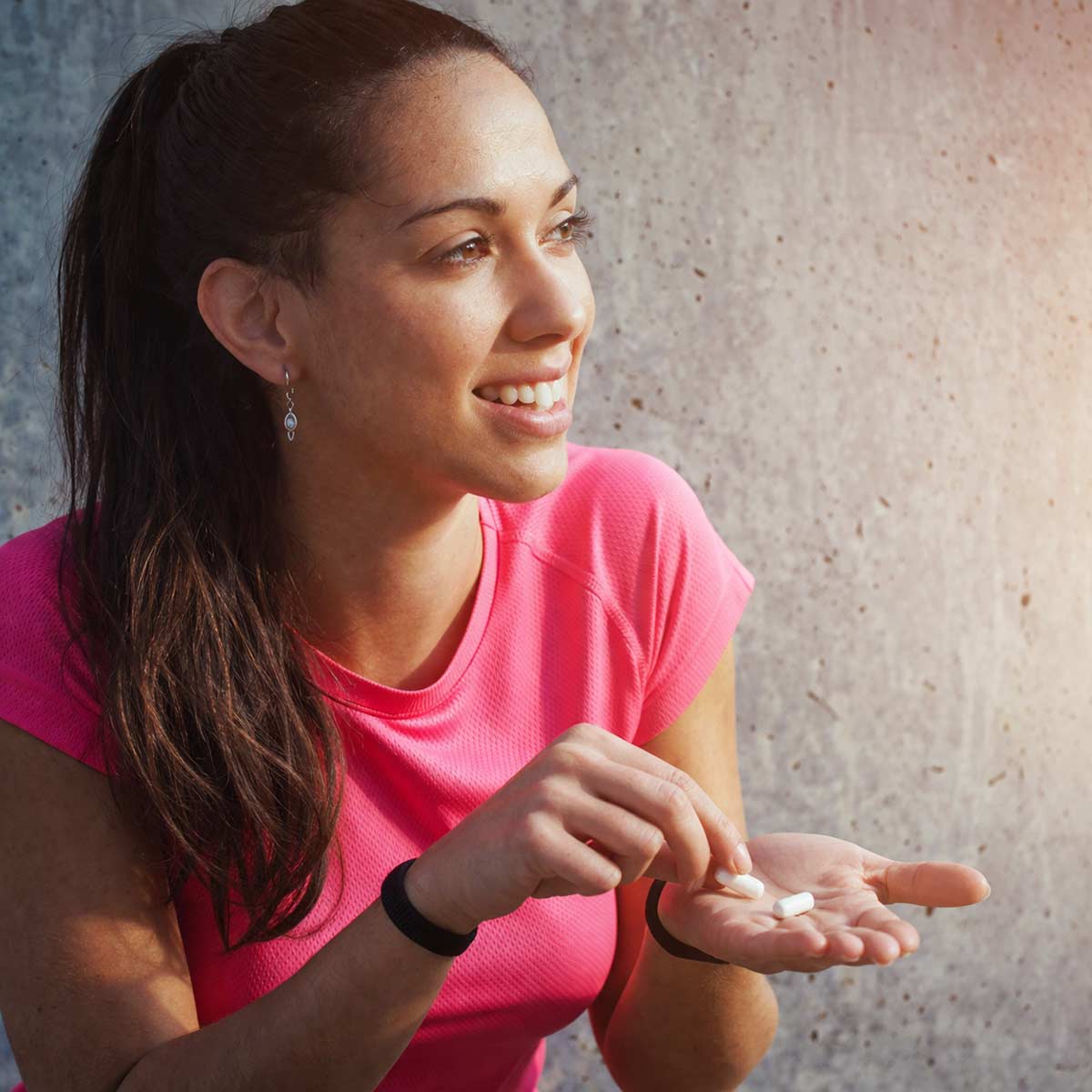 woman taking salt hydration capsules during her jog