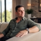 man resting on the couch looking out the window